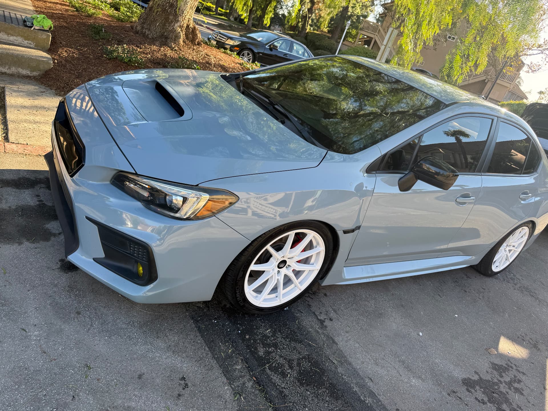 Gray Subaru WRX with white wheels after a full detail