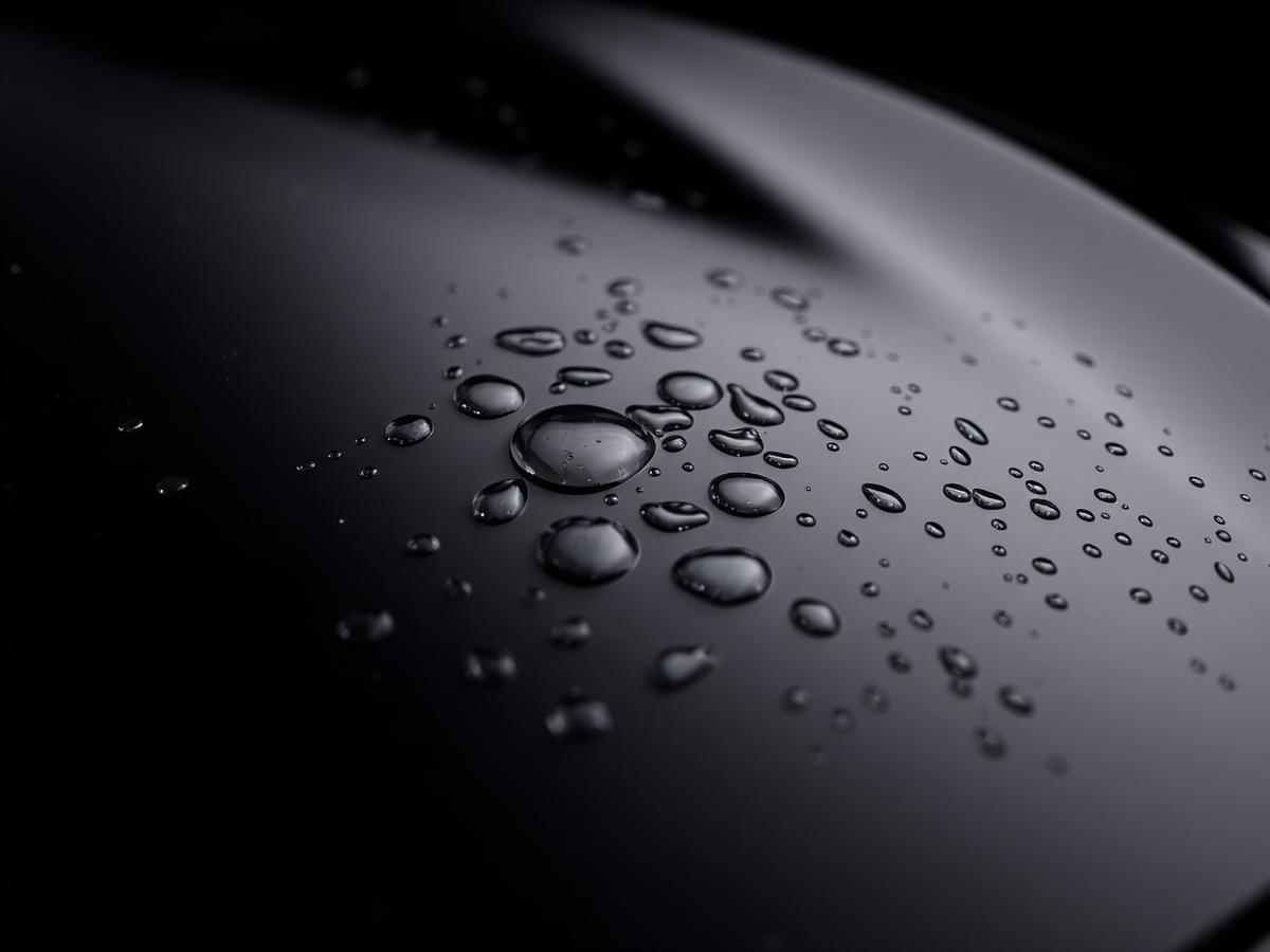 Water beading on a ceramic coated black car panel